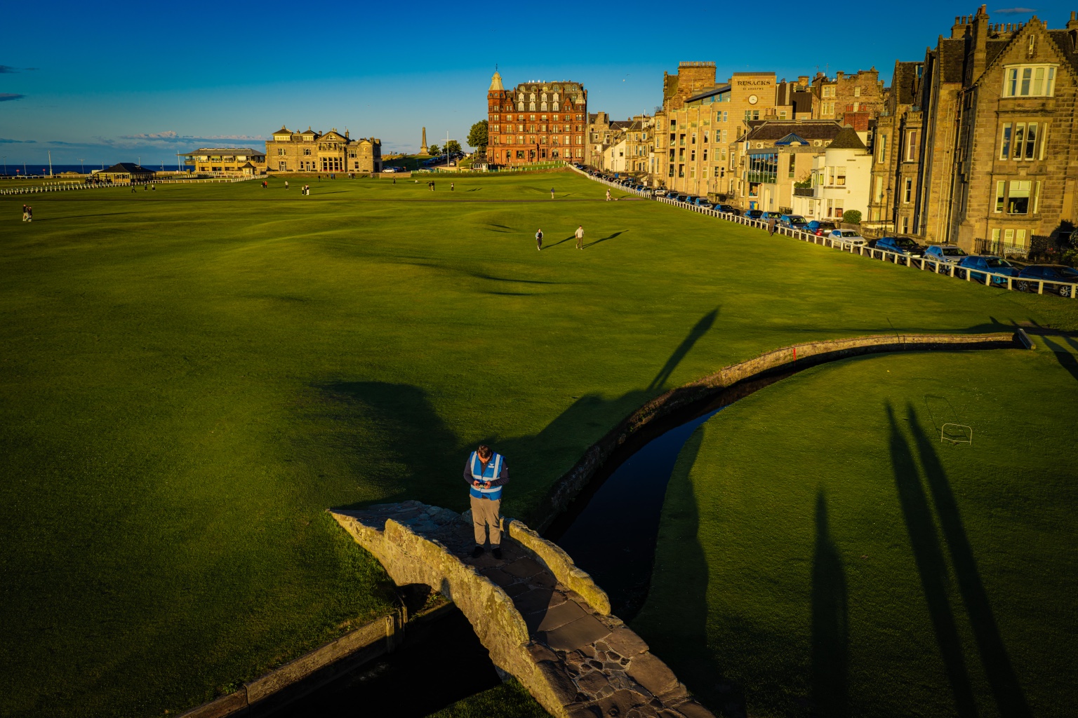 James Smith working with his drone controller on the Swilcan Bridge at the Old Course in St Andrews